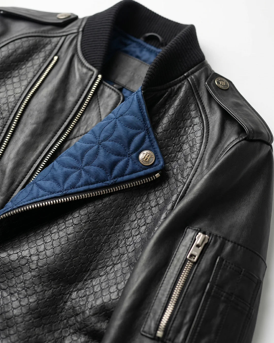 Black leather jacket with blue quilted lining on a white background