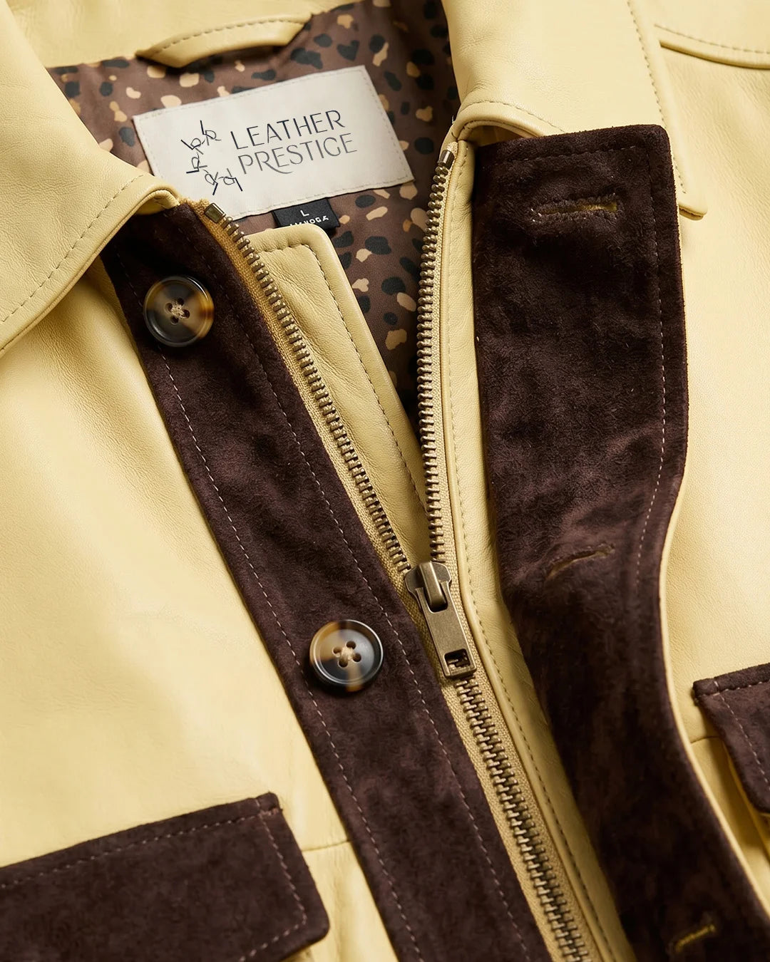 Close-up of a beige leather jacket with brown suede trim and a visible brand label.