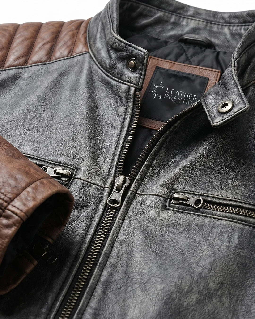 Close-up of a leather jacket with brown and black color scheme, featuring a brand label.