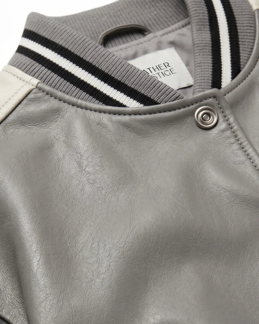 Gray leather jacket with striped sleeves and a brand label on a white background