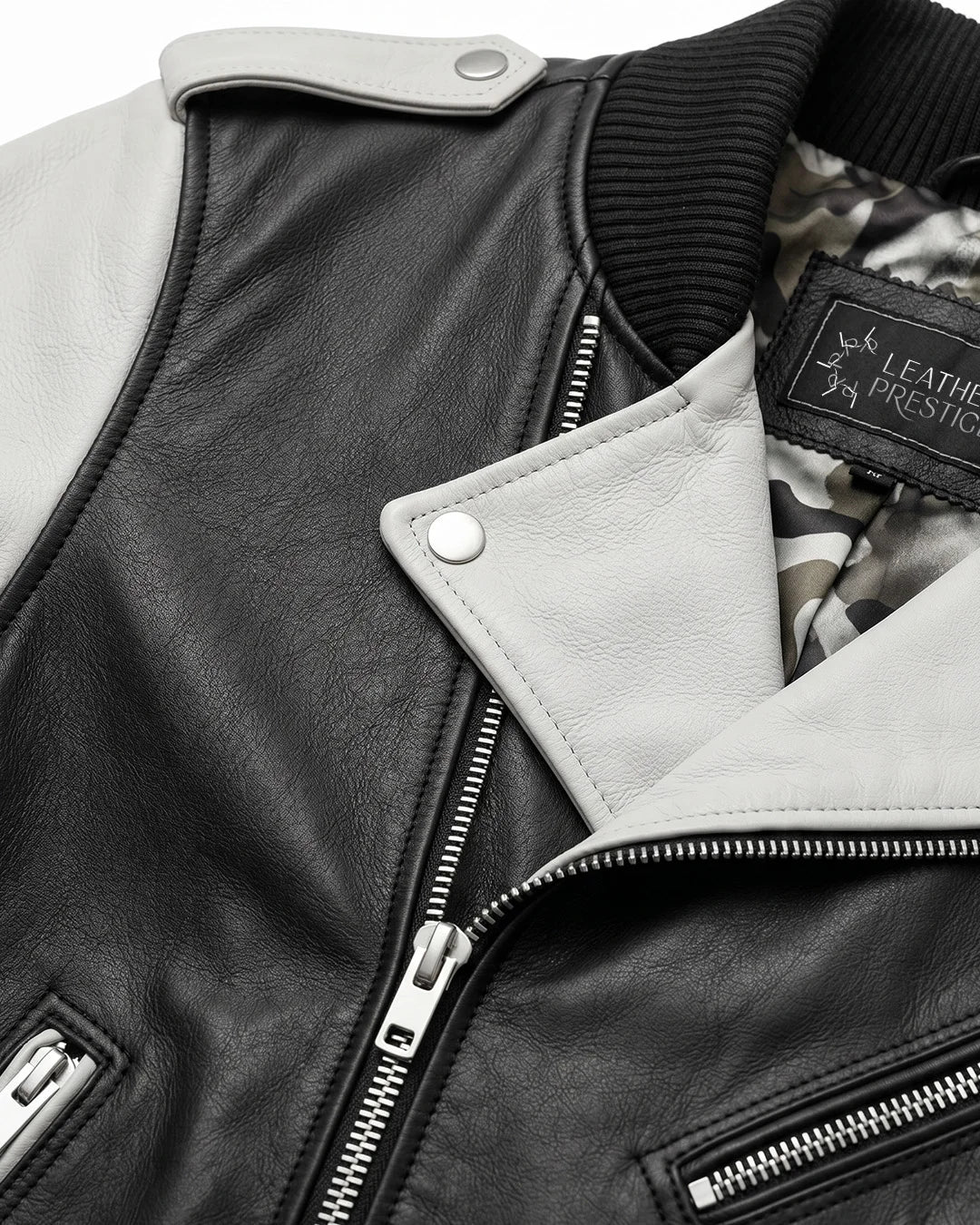 Close-up of a black leather jacket with a brand label on a light gray background