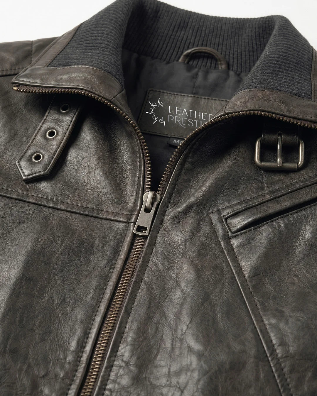 Close-up of a dark leather jacket with a visible brand label on a white background