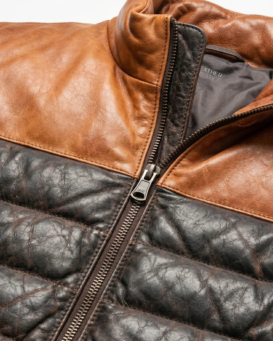 Close-up of a brown and black leather jacket with a zipper.