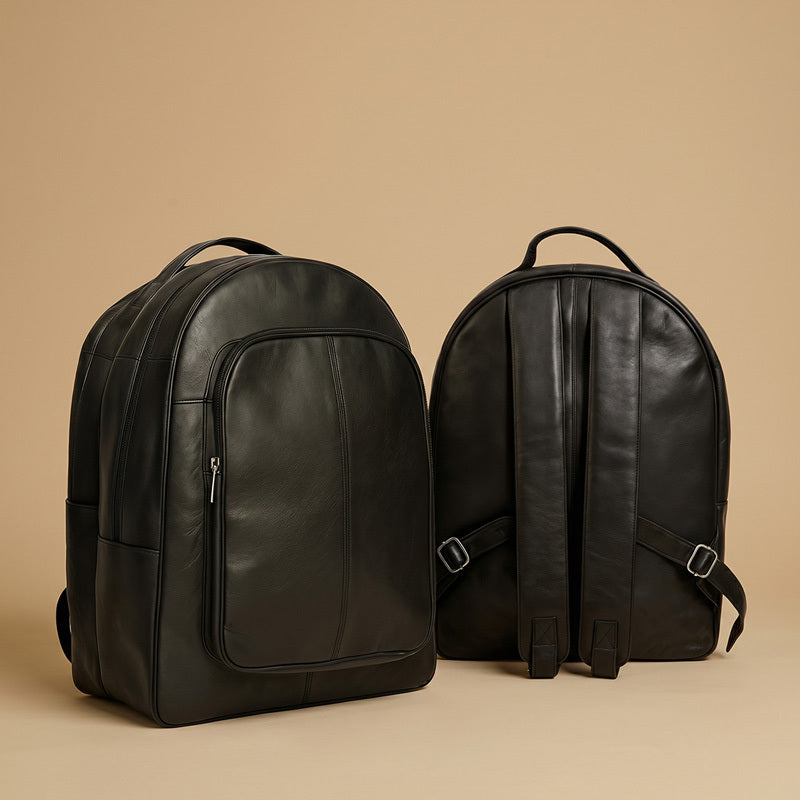 Two black leather backpacks on a beige background