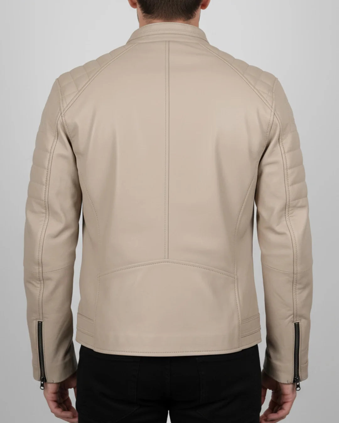 Beige leather jacket worn by a person on a plain background