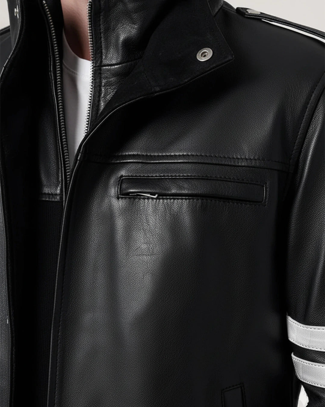 Close-up of a black leather jacket with reflective stripes on the sleeve.