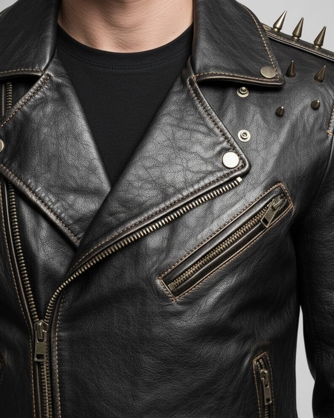 Close-up of a black leather jacket with spikes on a neutral background