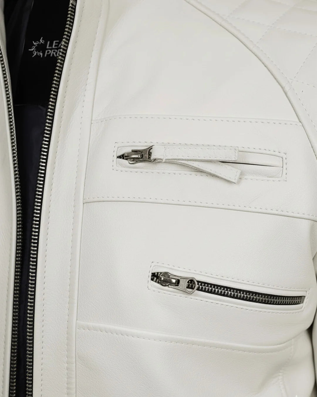 Close-up of a white leather jacket with zippers and a visible brand logo.