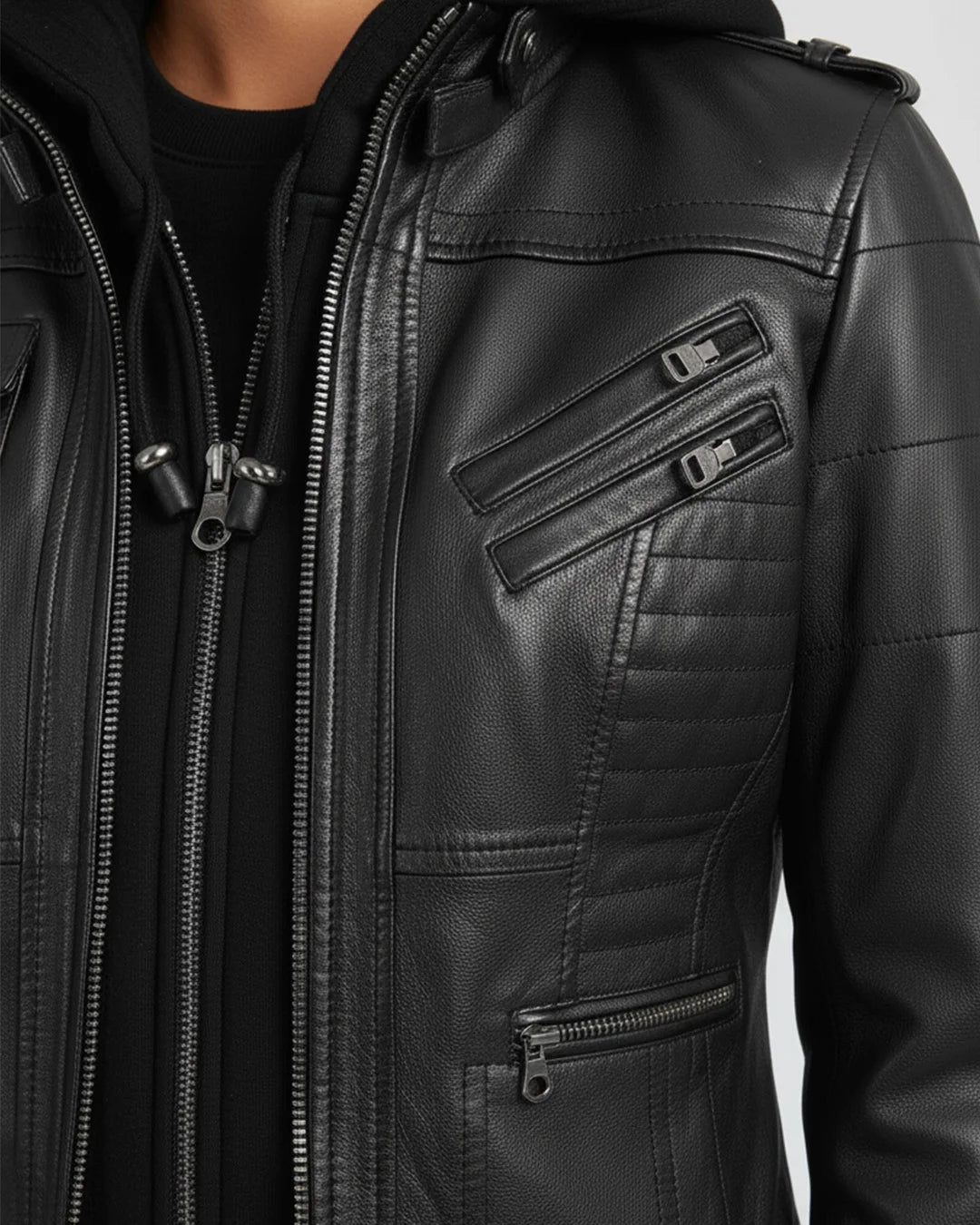 Close-up of a black leather jacket with zippers on a gray background