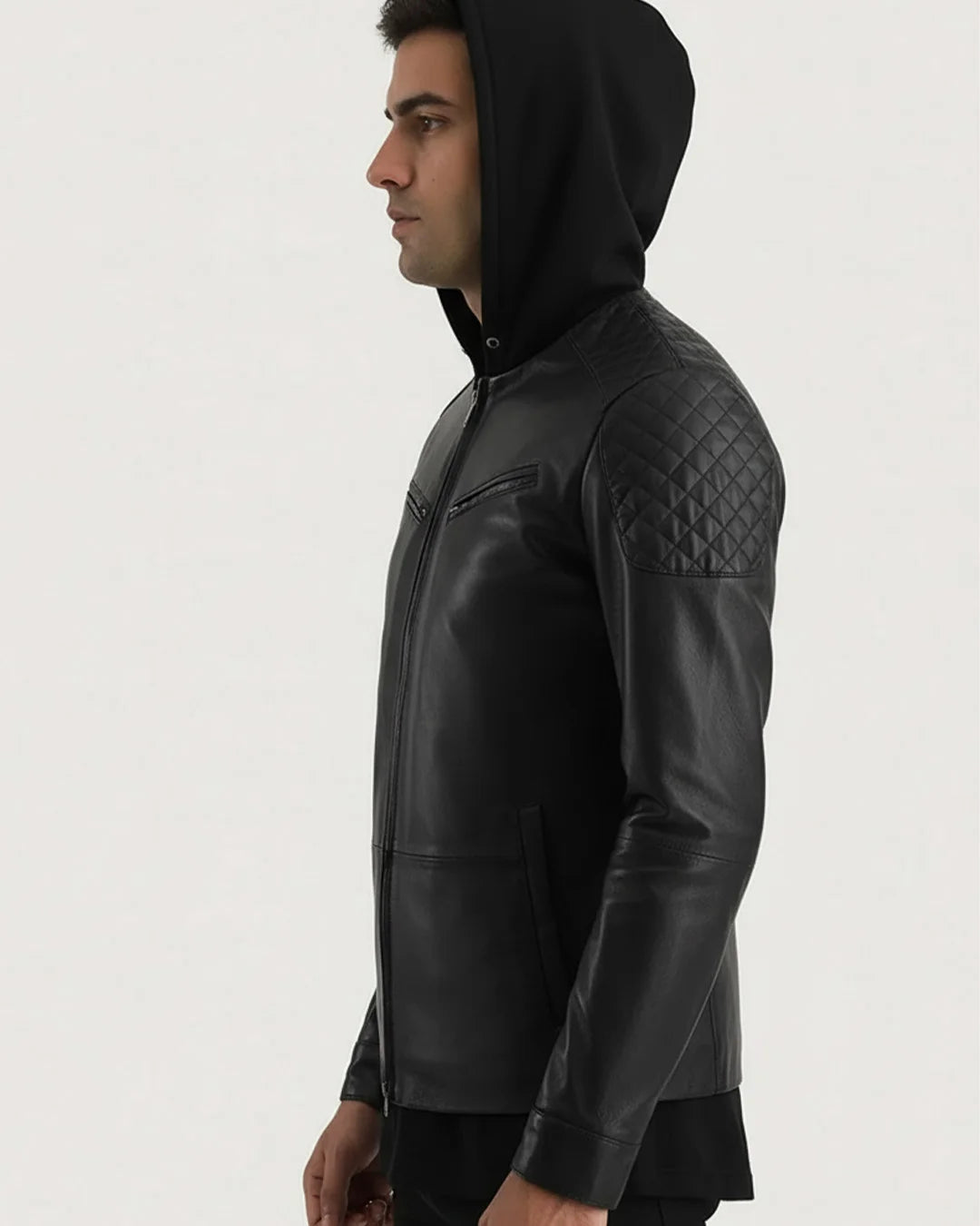Man wearing a black leather jacket with quilted arm design on a light gray background