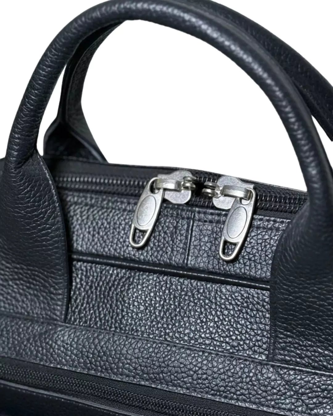 Black leather handbag with silver zippers on a white background