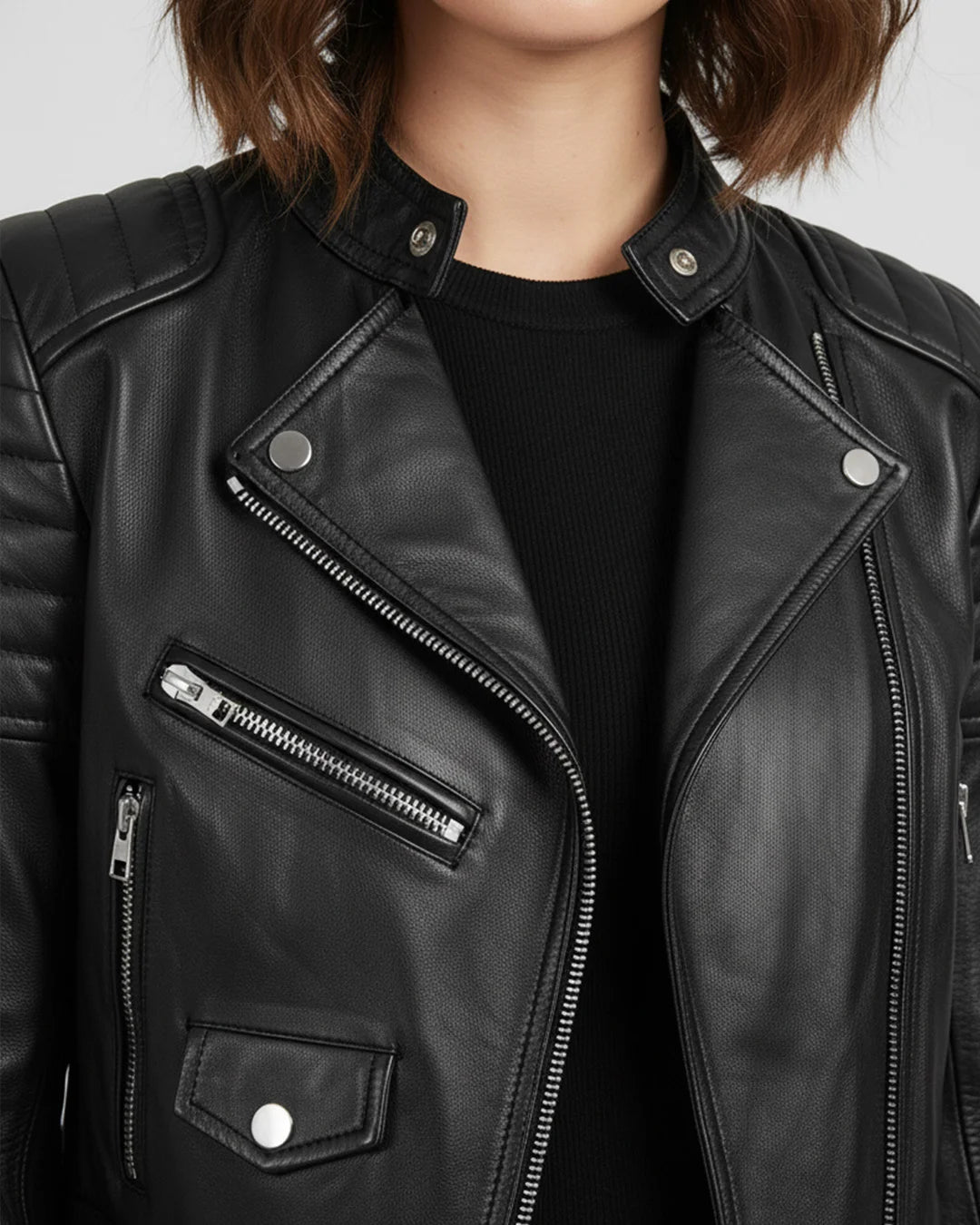 Black leather jacket with zippers and buttons on a plain background